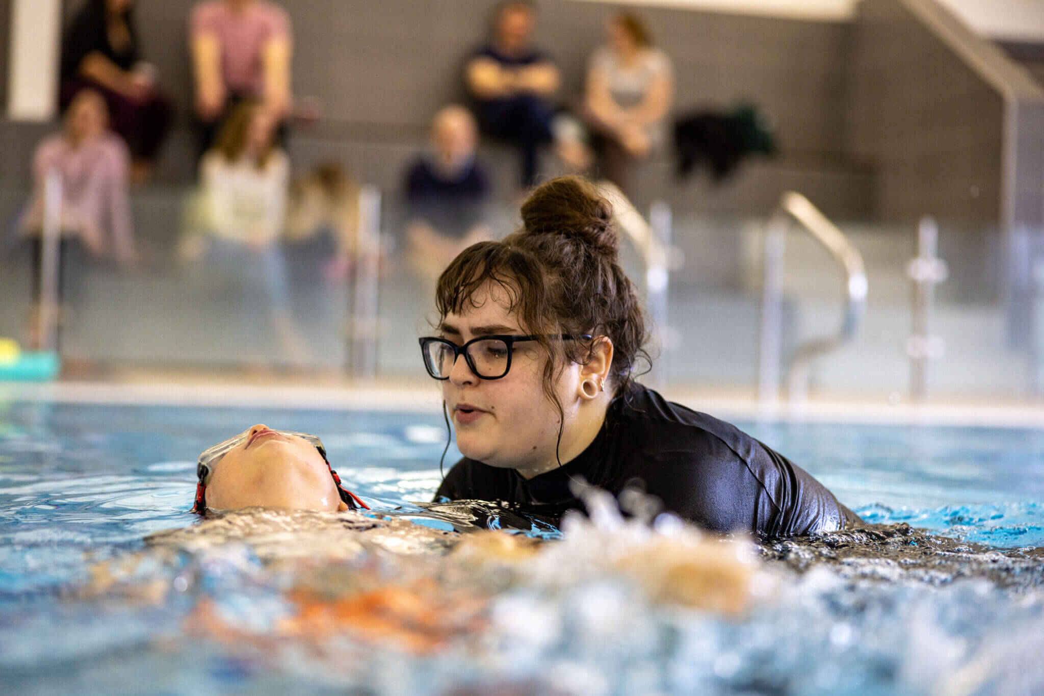 Instructor assisting learner to float