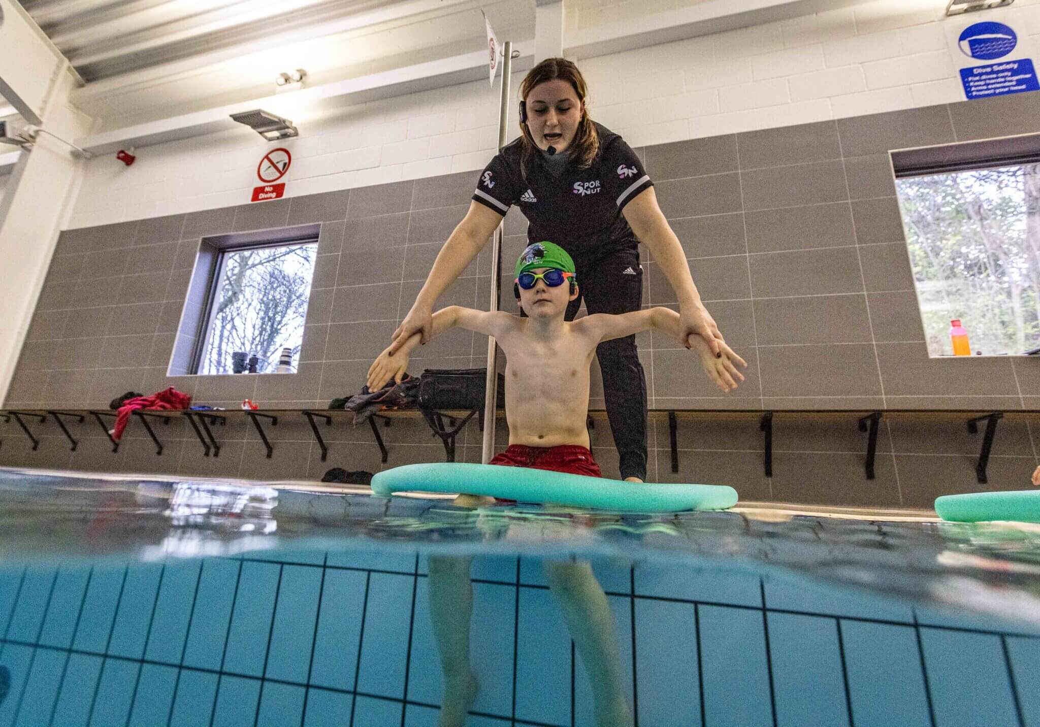Teacher and learner with swimming noodle