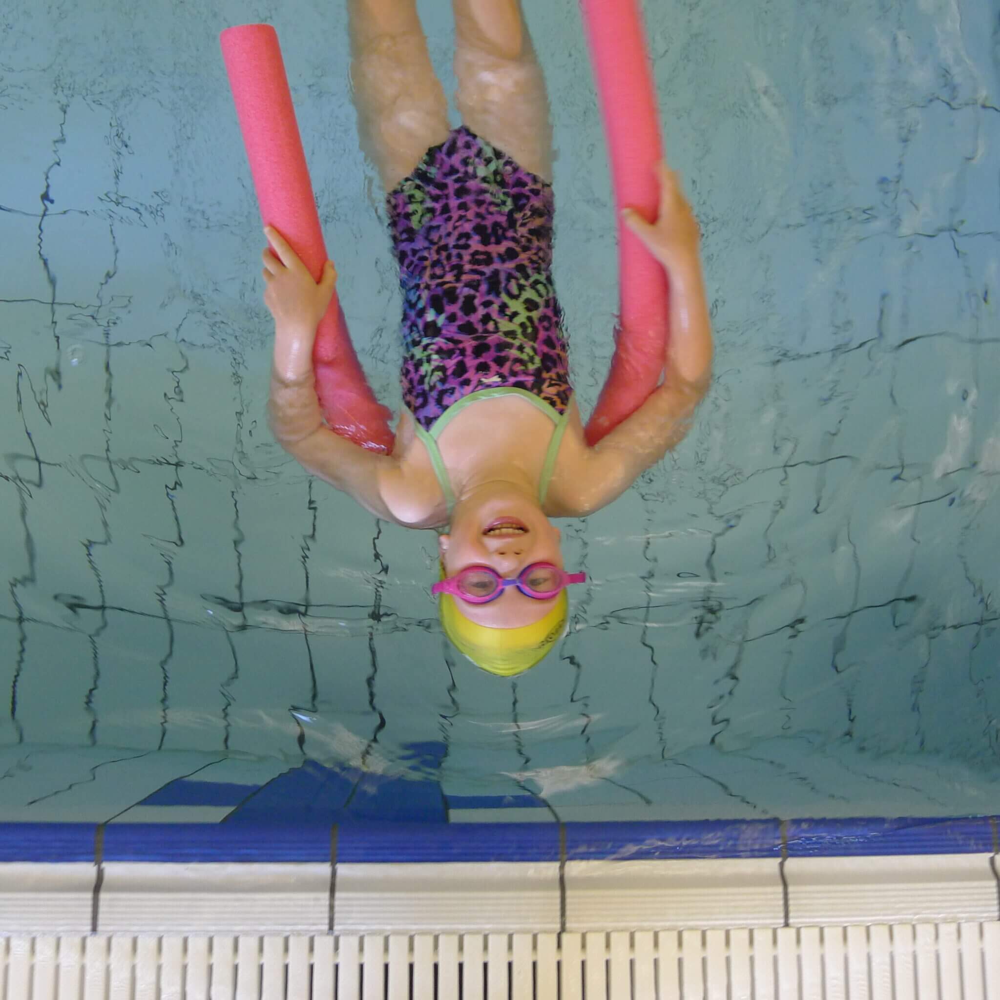 Child floating with swimming noodle