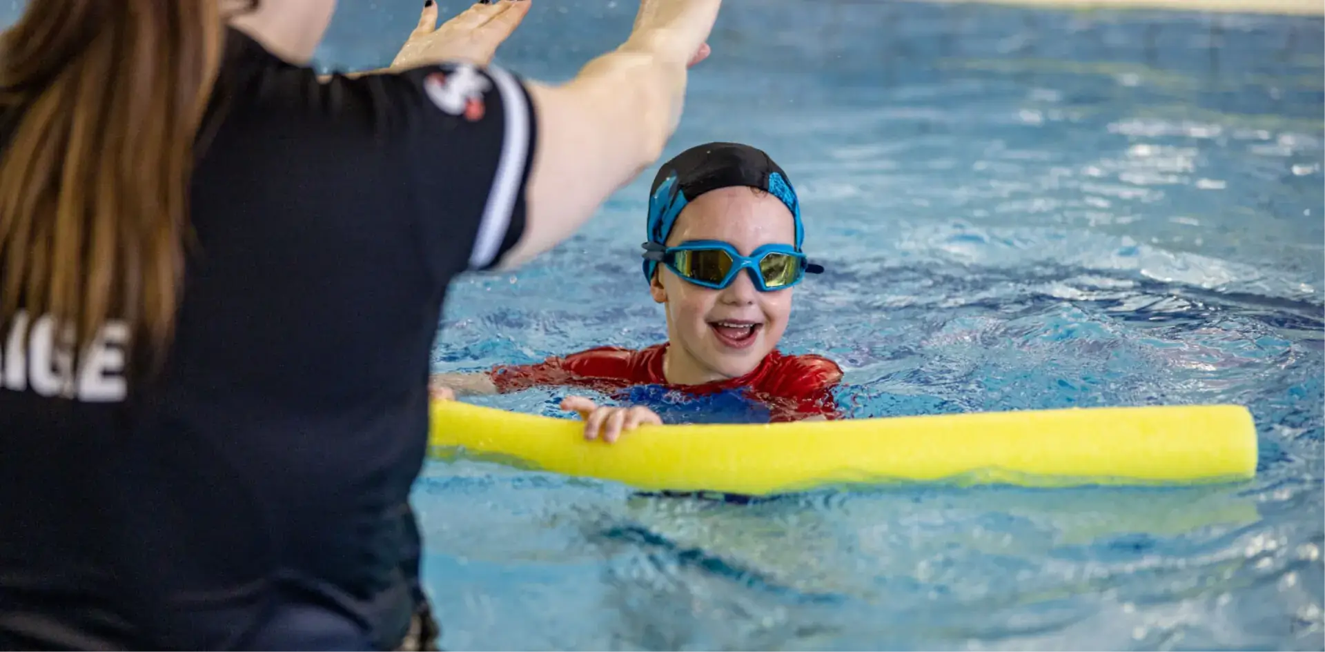 child in pool with instructor