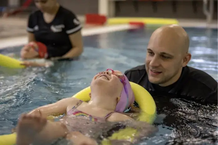 girl swimming with instructor